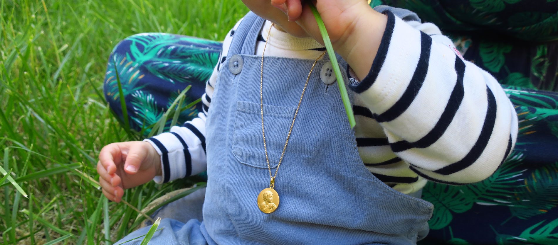 Médaille de baptême en or portée au cou d'un bébé